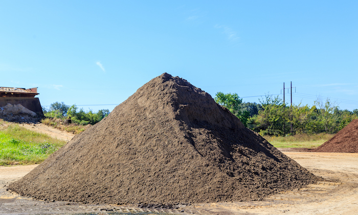 Mound of black Soil used for landscaping and driveways on display and for sale.