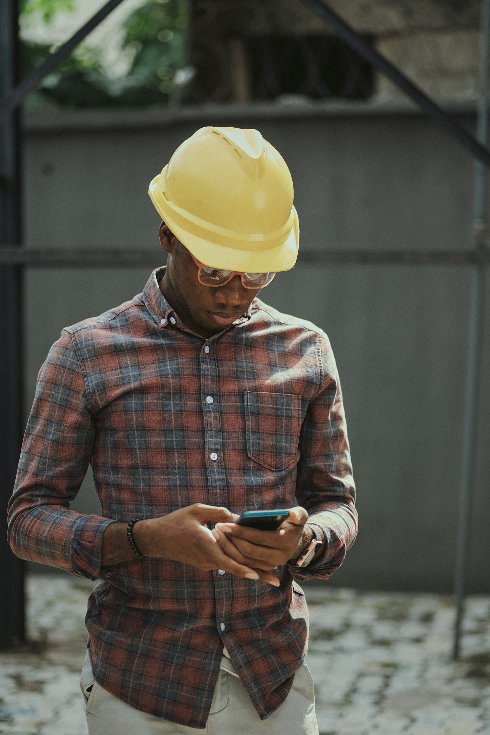 Construction worker in hard hat using a smartphone on site